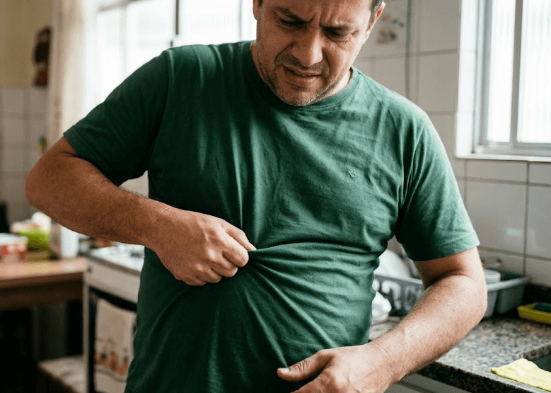 homem desconfort&aacute;vel com barriga marcando na camiseta